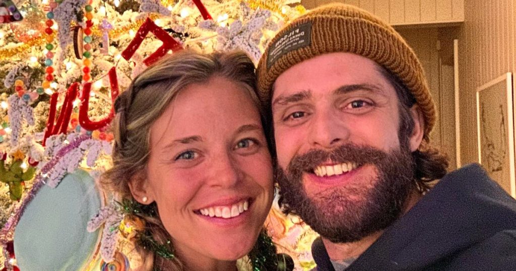 توماس ريت لا يستطيع التوقف عن الضحك على زوجته لورين وهي تتسلق السلم لتزيين شجرة عيد الميلاد الطويلة