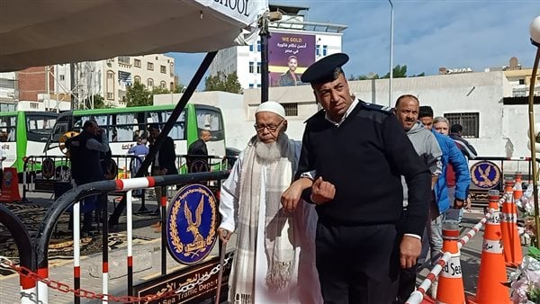 أفراد الشرطة يساعدون كبار السن وذوي الهمم أمام لجان التصويت بالغردقة