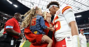 بريتاني ماهومز الحامل هي سيدة ترتدي اللون الأحمر وترتدي معطفًا أنيقًا في لعبة Chiefs Away في فيغاس
