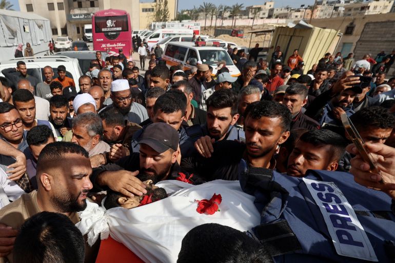 EDITORS NOTE: Graphic content / Mourners bid farewell to Palestinian journalist Hassan Aslih, killed at dawn in an Israeli strike which hit the surgeries building at the Nasser hospital, during his funeral procession in Khan Yunis in the southern Gaza Strip on May 13, 2025.