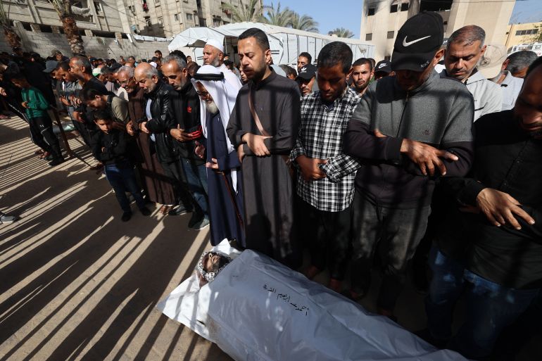 EDITORS NOTE: Graphic content / Mourners pray over the body of Palestinian journalist Hassan Aslih, killed at dawn in an Israeli strike which hit the Nasser hospital in Khan Yunis, during his funeral in the southern Gaza Strip city on May 13, 2025.