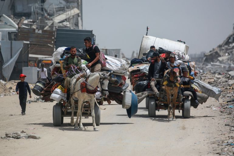 Palestinians move with their belongings as they flee the northern cities of Jabalia and Beit Lahia Gaza Strip towards Gaza City amid continuous Israeli strikes in the besieged Palestinian territory on May 17, 2025. (Photo by Bashar TALEB / AFP)