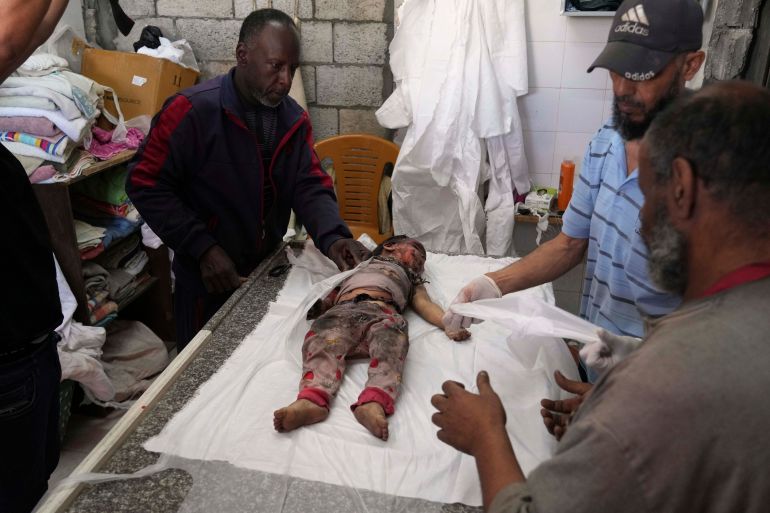 EDS NOTE: GRAPHIC CONTENT - The body of 2-year-old Farah Al Baz, a Palestinian child killed in an Israeli army airstrike that struck her family's home, is brought to Al-Aqsa Hospital in Deir al-Balah, Gaza, on Wednesday, May 21, 2025. (AP Photo/Abdel Kareem Hana)