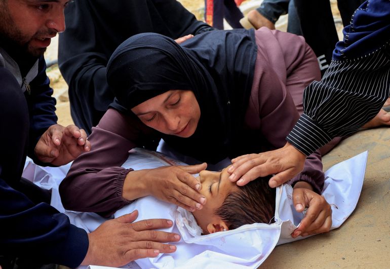 SENSITIVE MATERIAL. THIS IMAGE MAY OFFEND OR DISTURB Mourners react as they look at the body of a Palestinian boy killed in an Israeli strike, at Nasser hospital, in Khan Younis, southern Gaza Strip, May 18, 2025. REUTERS/Hatem Khaled TPX IMAGES OF THE DAY