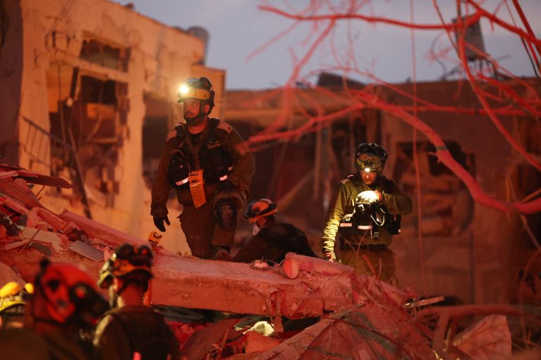 Responders search through building rubble following a strike by an Iranian missile in the Israeli city of Bat Yam, south of Tel Aviv, early on June 15, 2025.