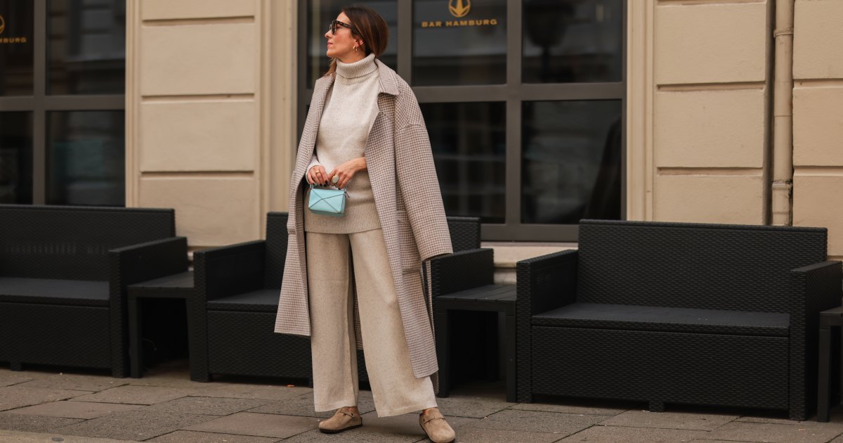 إليز سوهو ترتدي صندل بيركنستوك باللون البيج، وقطعتين من جوزيف بيج، ومعطف نانوشكا باللون البيج، وحقيبة أطفال صغيرة زرقاء من Loewe في 30 أغسطس 2021 في هامبورغ، ألمانيا.